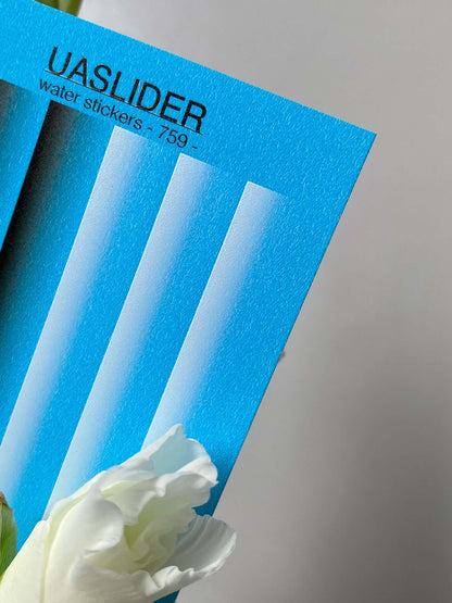 Nail Water Decal 759 on a blue sheet with white floral elements, displaying vivid water slide design features.